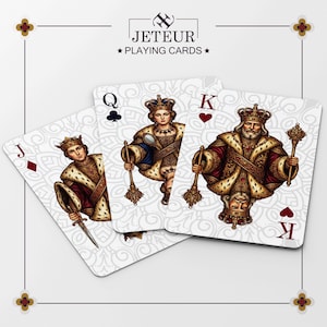 May include: Three playing cards from the Jeteur Playing Cards deck, featuring the Jack of diamonds, Queen of clubs, and King of hearts. Each card displays a detailed, ornate illustration of a royal figure in gold and red attire against a white background.