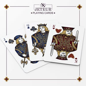 May include: Playing cards showing the Jack of Spades, Queen of Clubs, and King of Hearts. The cards have detailed illustrations with gold accents on a white background. The brand name "JETEUR PLAYING CARDS" is displayed at the top.