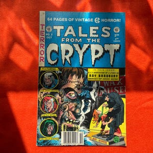 Puede incluir: Una portada de cómic vintage con un monstruo con puntos de sutura y una cara verde. El cómic se titula "Tales from the Crypt" y es el número 2. La portada también presenta una historia de Ray Bradbury.