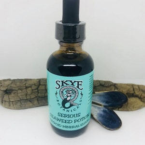 May include: A glass bottle with a black dropper top and a blue and white label that reads "Skye Botanicals Serious Seaweed Potion Thyroid Mineral Elixir".