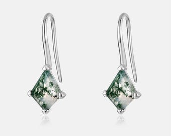 May include: A pair of silver drop earrings. Each earring features a square-cut, moss agate gemstone with green and white patterns, set in a silver frame. The earrings have a simple hook design.