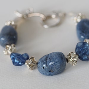 Denim Fancy: blue sponge coral nuggets highlighted  by sapphire-colored hand-made lampwork beads in 7 inch bracelet