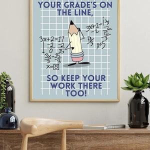 May include: A framed poster with a light blue background and a grid pattern. The poster features a cartoon pencil character and mathematical equations. Text on the poster reads, "YOUR GRADE'S ON THE LINE, SO KEEP YOUR WORK THERE TOO!"