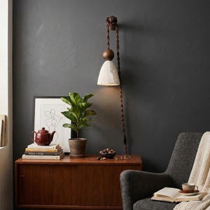 May include: A set of three ceramic nesting bowls in graduating sizes. The bowls feature a speckled, matte finish in shades of cream, light brown, and dark brown. The largest bowl measures approximately 8 inches in diameter.