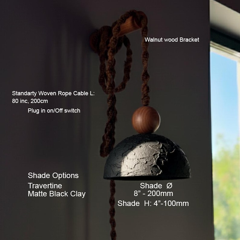 May include: A pendant light fixture with a matte black clay shade, 8 inches in diameter and 4 inches high. It features a walnut wood bracket and a woven rope cable, 80 inches long, with a plug-in on/off switch.