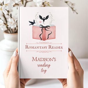 Könnte beinhalten: Ein personalisiertes Leseprotokoll mit dem Text "Romantasy Reader" und "Madison's reading log". Das Cover zeigt eine Aquarellillustration eines rosa Buches mit schwarzem Band, einem Drachen und einem Vogel.