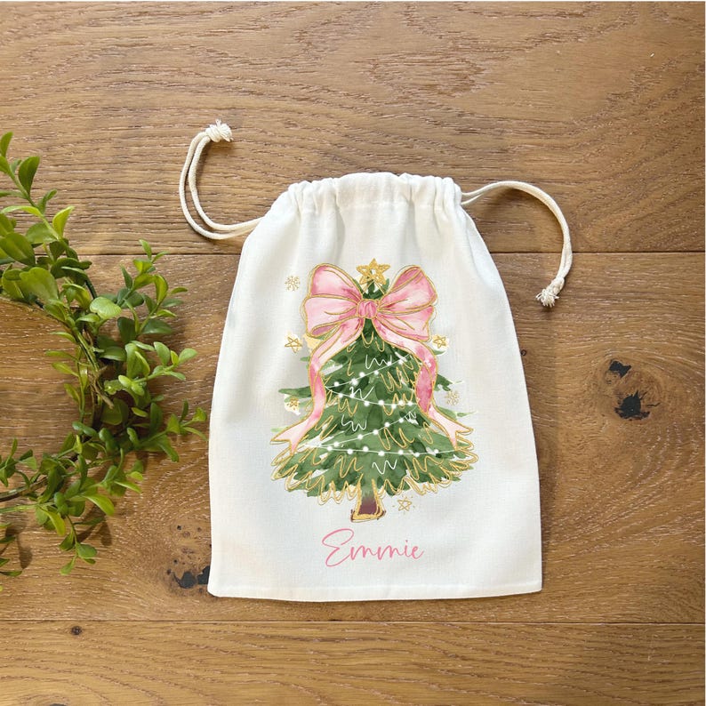 Personalized Christmas Gift Bag Custom Name Drawstring Closure Cotton Fabric Holiday Present Wrapping Tree Pattern Design Pink Bow Accent Reusable Packaging Solution Eco Friendly Alternative Party Favor Bags Stocking Stuffer Container