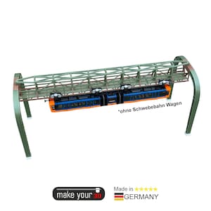 Könnte beinhalten: Modell einer Schwebebahn mit einem orangefarbenen und blauen Triebwagen. Der Zug ist an einer grünen Metallgleisstruktur aufgehängt. Der Text "*ohne Schwebebahn Wagen" ist sichtbar. Die Wörter "make your 3D" und "Made in Germany" sind ebenfalls sichtbar.