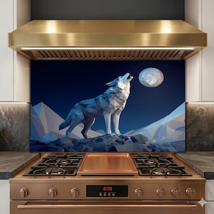 Puede incluir: Un diseño geométrico de un lobo aullando bajo la luna llena, sobre un cielo azul oscuro y un paisaje montañoso. La obra de arte se muestra como un protector contra salpicaduras de cocina, con una estufa y campana extractora de color cobre.