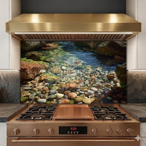 May include: A kitchen range with a copper-colored hood and a backsplash featuring a vibrant image of a clear, shallow stream bed filled with colorful rocks and a few seashells. The range has a copper-colored cooktop and a digital clock displaying 10:09.