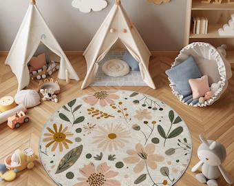 Può includere: Tappeto rotondo con motivo floreale su sfondo crema, con fiori e foglie rosa, gialle e verdi. Sullo sfondo sono visibili due piccole tende a teepee e giocattoli per bambini.