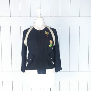 May include: Black bomber jacket with white fur trim on the collar and sleeves. The jacket has embroidered bird and flower designs on the front.