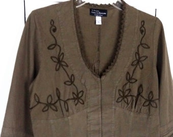 May include: A brown linen jacket with embroidered floral details and a lace trim. The jacket has a zipper closure and a v-neck. The label reads "C2 Design Natural Editions".