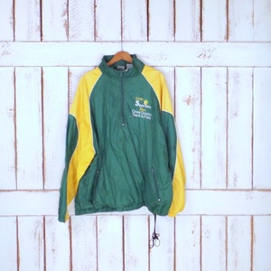 May include: Green and yellow windbreaker jacket with a zipper closure and a drawstring hood. The jacket has a white stripe on the sleeves and the text "Spartans Cross Country Track & Field" on the front.