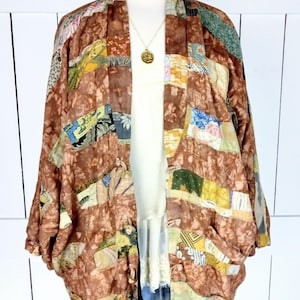 May include: A brown patchwork kimono with a floral pattern. The kimono is made of silk and has a relaxed fit. It is a vintage piece and has a unique style.