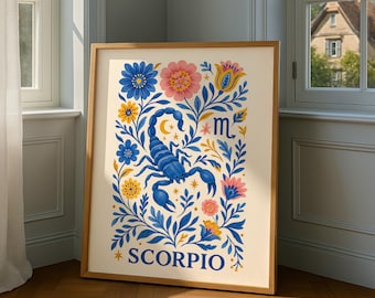 May include: A framed art print featuring a blue scorpion illustration surrounded by colorful flowers and foliage. The word "SCORPIO" is at the bottom. The artwork has a cream background and is in a wooden frame. The print is leaning against a wall.