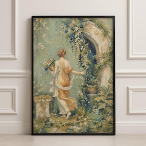 May include: A framed wall art print depicting a figure in a flowing golden-toned garment walking toward a stone archway. The figure carries a basket of flowers in a lush garden setting with blue and white blossoms, greenery, and stone pedestals.