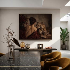 Leopard print showing a back-turned woman wrapped in burgundy fabric beside a reclining leopard in a dimly lit vintage interior.