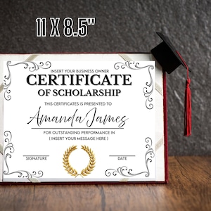 以下が含まれることがあります： 11 x 8.5インチの奨学金証明書が表示されています。「Certificate of Scholarship」と「Amanda James」のテキストと装飾的な黒いボーダーが特徴です。赤いタッセルが付いた卒業キャップがフレームの上にあります。