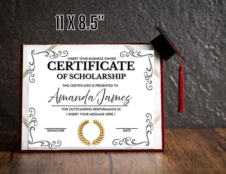 以下が含まれることがあります： 11 x 8.5インチの奨学金証明書が表示されています。「Certificate of Scholarship」と「Amanda James」のテキストと装飾的な黒いボーダーが特徴です。赤いタッセルが付いた卒業キャップがフレームの上にあります。