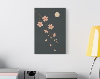 May include: A canvas print featuring a minimalist illustration of cherry blossoms. The artwork depicts a branch with pink flowers and falling petals against a dark grey background, with a full moon in the upper right corner.