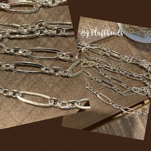 Op de afbeelding: Een close-up van verschillende zilveren ketting schakels. De kettingen zijn gemaakt van ovale schakels en zijn in een gelaagd patroon gerangschikt. De tekst "By Plufffbeads" is zichtbaar in de afbeelding.