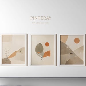 Może przedstawiać: Trzy oprawione abstrakcyjne wydruki artystyczne w neutralnych odcieniach beżu, brązu i pomarańczy. Wydruki są wyświetlane na białej ścianie z tekstem "PINTERAY Soft art for quiet walls". Grafika przedstawia geometryczne i organiczne formy.
