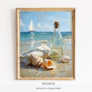 Puede incluir: Pintura enmarcada de una escena de playa con un velero en el horizonte. Una botella de vidrio transparente con un tapón de corcho está sobre la arena, junto a conchas marinas y un paño blanco. La pintura tiene un estilo suave e impresionista.