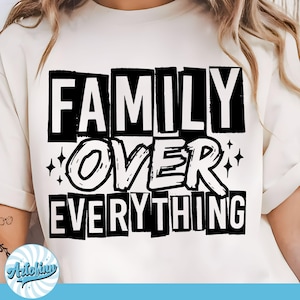 May include: Cream-colored t-shirt with the text "FAMILY OVER EVERYTHING" in a bold, black, block-letter design. The word "OVER" is in a stylized font, with star accents. A casual, everyday wear tee.