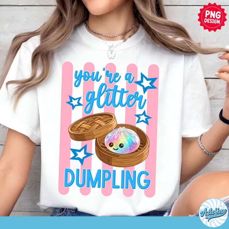 May include: White t-shirt with a graphic design featuring a cartoon dumpling inside a bamboo steamer. The text "you're a glitter dumpling" is in blue, with pink stripes and blue stars.