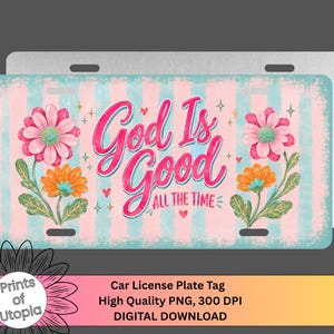 May include: A rectangular metal car license plate featuring a light blue and pink vertical striped background. The text God Is Good ALL THE TIME is printed in a bold pink script font, surrounded by pink and orange flowers, small hearts, and stars.