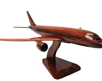 Könnte beinhalten: Ein handgefertigtes Holzflugzeugmodell in einem satten, rotbraunen Finish. Das Modell verfügt über detaillierte Flügel, Triebwerke und einen Ständer. Ideal für Luftfahrtbegeisterte und Sammler.