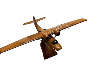 Könnte beinhalten: Ein Holzmodell eines alten Wasserflugzeugs mit brauner Holzoptik. Das Modell ist auf einem Holzsockel montiert.