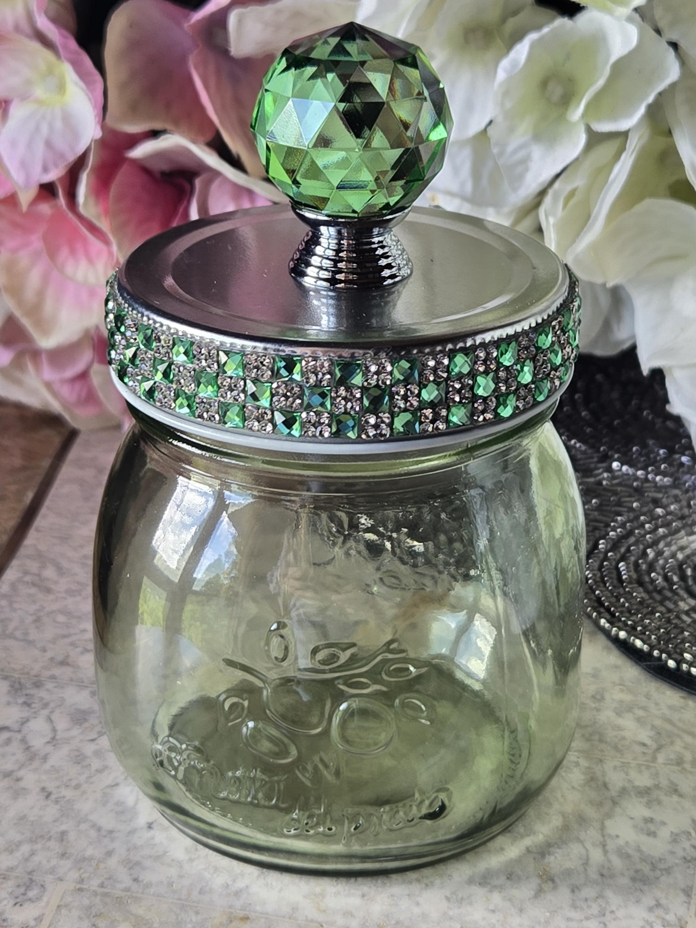 Green glass jar with decorative lid and fairy lights