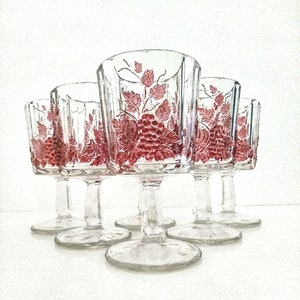 May include: Set of six clear glass stemmed wine glasses with a pink grape design.