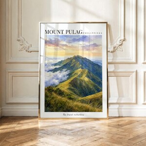 May include: A vertical rectangular wall art print featuring a landscape painting of Mount Pulag in the Philippines. The image displays green mountain peaks rising above clouds under a sunset sky. The text reads MOUNT PULAG PHILIPPINES and The travel collection.