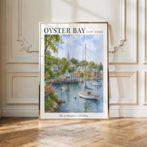 May include: A framed art print titled OYSTER BAY NEW YORK from The northeastern collection, featuring a watercolor painting of a harbor with sailboats, lush green trees, and coastal houses under a blue sky with white clouds.