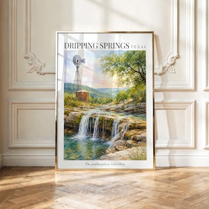 May include: A framed wall art print titled DRIPPING SPRINGS TEXAS featuring a landscape painting of a waterfall cascading over rocky ledges, a metal windmill, and a water tank under a soft sky. The text The southwestern collection appears below.