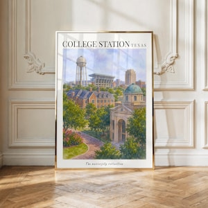 May include: A framed art print titled COLLEGE STATION TEXAS featuring a watercolor-style illustration of a university campus with a water tower, stadium, and brick buildings surrounded by green trees under a blue sky with white clouds.