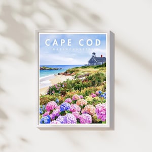 Peut inclure: Une impression encadrée de Cape Cod, Massachusetts. L'œuvre représente une scène côtière avec une plage, l'océan et une maison avec un phare. Des hortensias colorés dans les tons de rose, de violet et de bleu sont au premier plan.