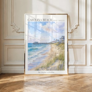 Puede incluir: Una lámina de arte mural vertical con una acuarela de Carolina Beach, Carolina del Norte. La escena muestra una playa de arena con hierba de duna alta, un muelle de madera que se extiende hacia el océano azul y casas bajo un cielo nublado.