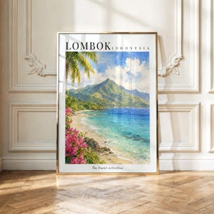 May include: A vertical framed art print featuring a watercolor painting of a tropical beach in Lombok, Indonesia. The scene depicts a sandy shore, turquoise water, green mountains, and bright pink bougainvillea flowers under a blue sky.