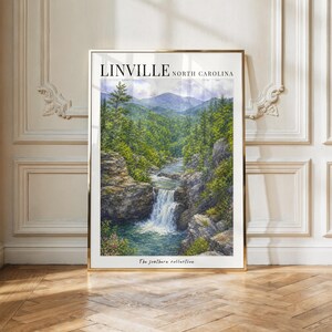 Peut inclure: Une impression d'art mural verticale présentant une peinture à l'aquarelle de Linville, en Caroline du Nord. L'œuvre représente une cascade s'écoulant sur un terrain rocheux dans un bassin, entourée d'arbres verts et de montagnes bleues.