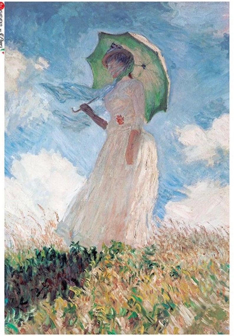 May include: A woman in a white dress holds a green umbrella while standing in a field of tall grass. The sky is blue with white clouds.