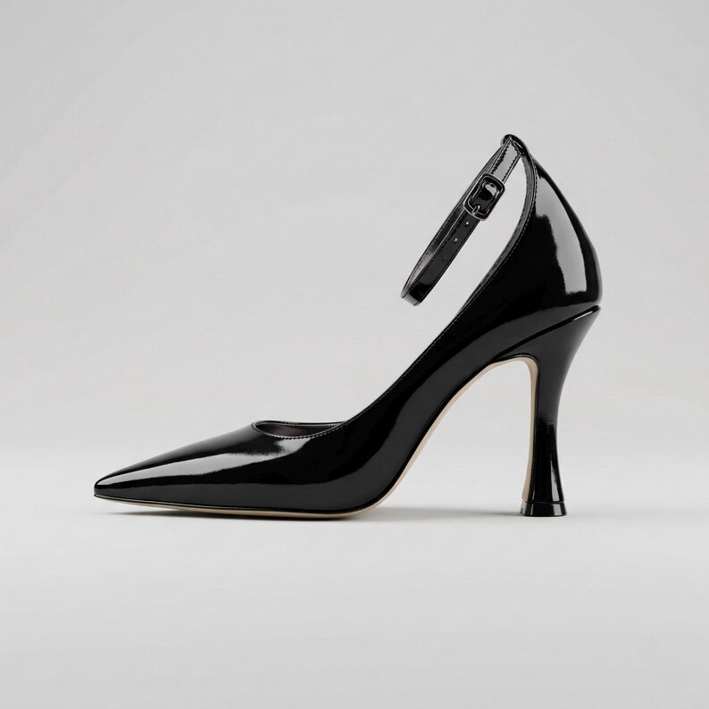 Peut inclure: Une escarpin noir verni avec un bout pointu et une bride de cheville. Le talon aiguille mesure environ 7.6 cm de haut. La chaussure a un design &eacute;l&eacute;gant et moderne, adapt&eacute; aux occasions formelles.