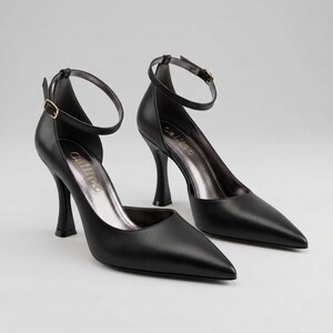 Peut inclure: Une paire d'escarpins noirs en cuir avec des bouts pointus et des brides de cheville. Les talons ont un design fin et incurv&eacute; et une semelle int&eacute;rieure argent&eacute;e m&eacute;tallique. La marque "Callipo" est visible sur la semelle int&eacute;rieure.