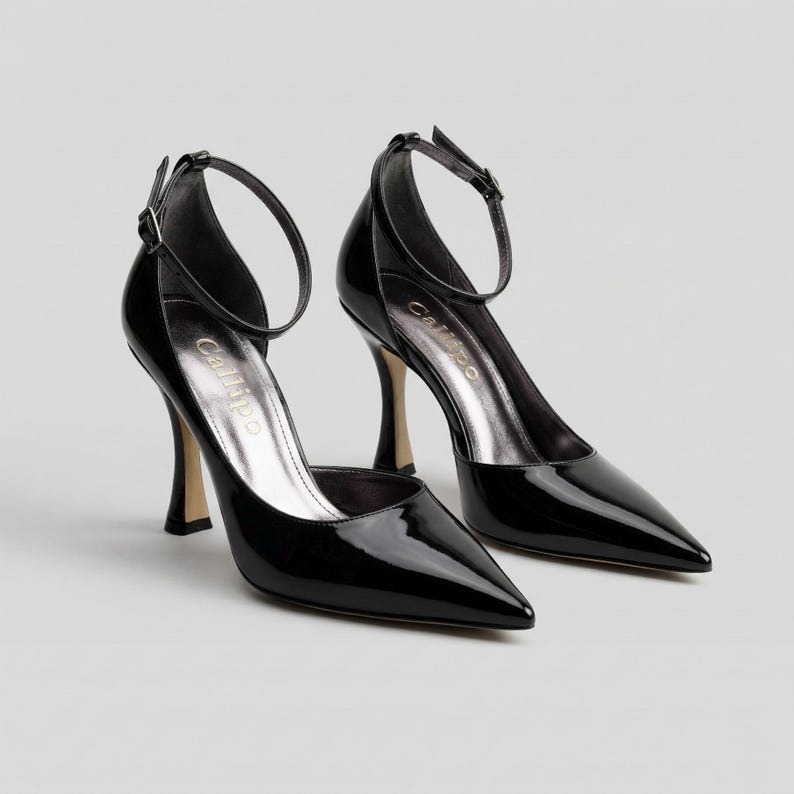 Peut inclure: Une paire d'escarpins noirs en cuir verni, &agrave; bout pointu et bride de cheville. Les talons aiguilles ont un int&eacute;rieur argent&eacute; m&eacute;tallique. La marque "Callipo" est visible sur la semelle int&eacute;rieure.