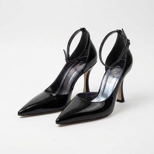 Peut inclure: Paire d'escarpins noirs en cuir verni &agrave; bout pointu et bride de cheville. Les talons aiguilles ont une finition m&eacute;tallique et le nom de la marque "Gallipo" est visible sur la semelle int&eacute;rieure.