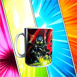 Peut inclure: Mug en céramique blanche avec une illustration de bande dessinée d'un personnage en costume noir et cape rouge, avec le mot "Spawn" en rouge. Le fond est un design de style bande dessinée coloré.