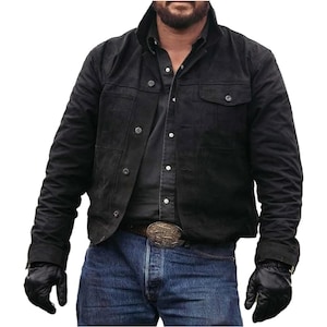 May include: Black suede jacket with button closures and two chest pockets. The jacket is worn over a button-down shirt and blue jeans. The person is also wearing black gloves and a belt with a decorative buckle.